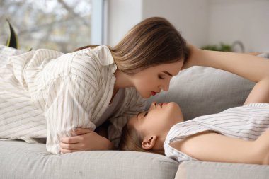 Evdeki koltukta oturan genç lezbiyen çift.