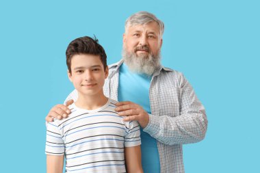 Mavi arka planda sevimli torunuyla mutlu büyükbaba.