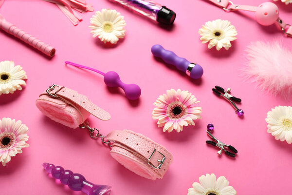 Секс-игрушки с цветами на розовом фоне