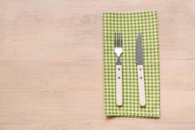 Ahşap arka planda peçete ve şık çatal bıçak takımı