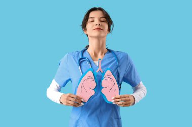 Mavi arka planda kağıt ciğerli kadın doktor.