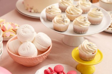 Tatlı standları, lezzetli beyaz kekler ve masadaki doğum günü partisi için diğer tatlılar.