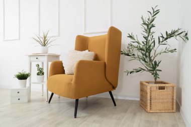 Kahverengi koltuklu, kahve masalı ve çiçekli bir oturma odası.