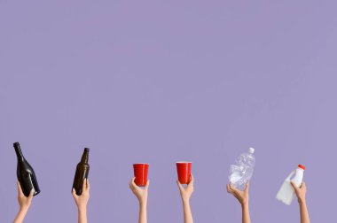 Leylak arka planında farklı çöpleri tutan kadın elleri. Geri dönüşüm kavramı