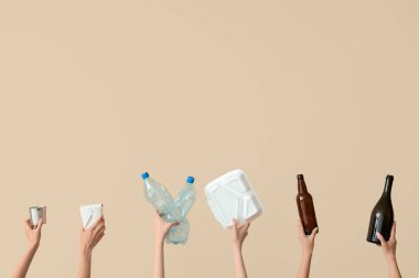 Bej arka planda farklı çöpleri tutan kadın elleri. Geri dönüşüm kavramı