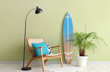 Konforlu koltuğu, lambası, çiçek ve sörf tahtasıyla modern oturma odasının içi