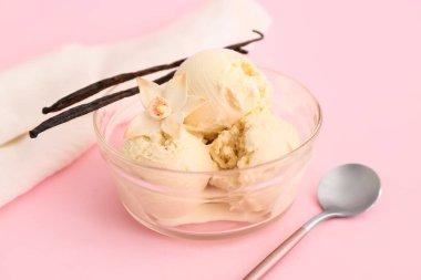 Pembe arka planda bir top vanilyalı dondurma.