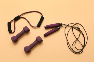 Genişletici, dambıl ve bej arka planda atlama halatı