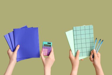 Yeşil zemin üzerinde not defterleri, kalem ve hesap makinesi olan kadın eller