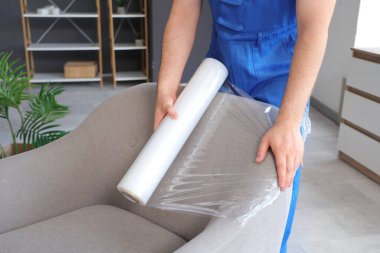 Mobilyaları polietilen filmle kaplayan yükleyici, yakın plan