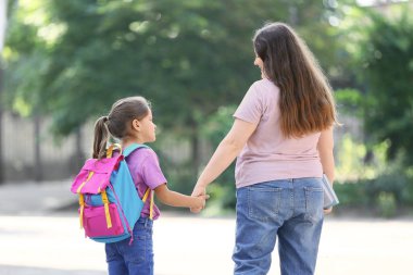 Annesiyle okula giden küçük bir kız.