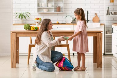 Anne ve kızı mutfakta okul için beslenme çantası hazırlıyorlar.