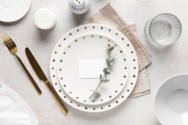 Boş kart, okaliptüs ve beyaz zemin üzerinde mum ile güzel masa ayarları