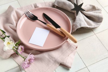 Boş kartlı şık masa ayarları ve beyaz karo arka planda güzel çiçekler