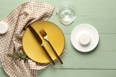 Okaliptüs ve yeşil ahşap arka planda mumlarla güzel bir masa.