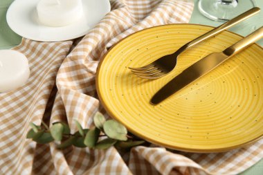 Okaliptüs ve yeşil ahşap arka planda mumlarla güzel bir masa.