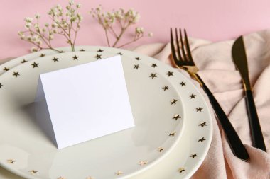 Boş kart ve pembe arka planda çigila çiçekleri olan güzel bir masa.