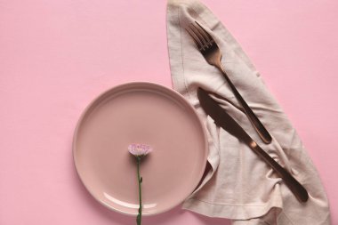 Pembe arka planda güzel çiçekli şık bir masa.