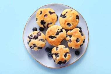 Mavi arka planda lezzetli yaban mersinli kek tabağı