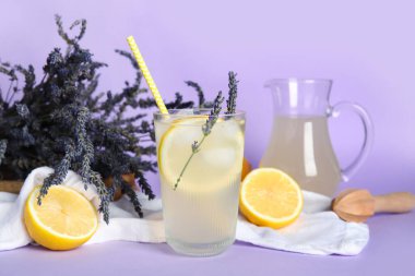 Bir bardak soğuk lavantalı limonata, limon ve çiçek.