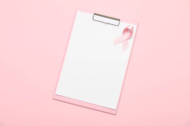 Pembe arka planda ipek kurdeleli boş bir pano. Göğüs kanseri kavramı