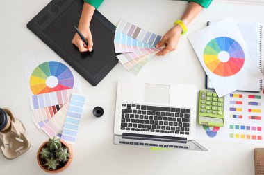 Tablet ve renk paletleri ile çalışan grafik tasarımcısı, en üstte görünüm