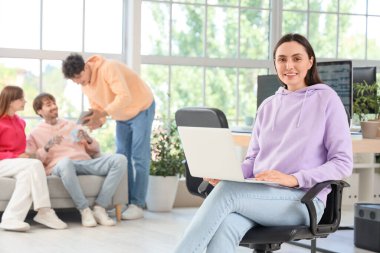 Ofiste dizüstü bilgisayarla çalışan kadın programcı