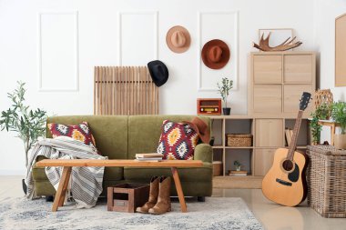 Oturma odasının içinde kovboy şapkaları, kanepe ve bank var.