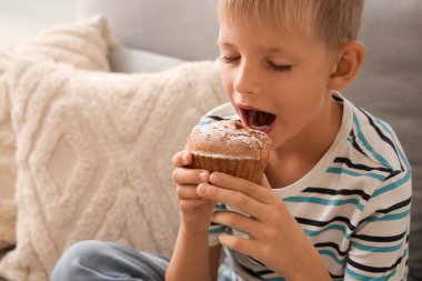 Küçük çocuk evde lezzetli çörekler yiyor, yakından.