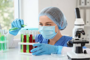 Laboratuvarda test tüpleri olan kadın kimyager, yakın plan.