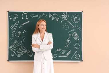 Sınıfta tahtaya yakın bayan öğretmen.