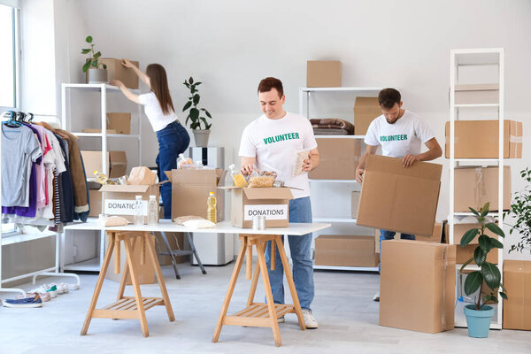 Male volunteer putting food into donation box in center