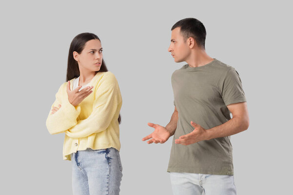 Молодая пара ссорится на светлом фоне
