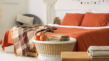 Büyük konforlu yatak ve sonbahar elmalarıyla süslü bir oda.