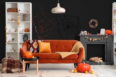 Cadılar Bayramı için kanepe ve şömineyle dekore edilmiş oturma odasının içi.