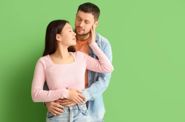 Yeşil arka planda öpüşen genç çift