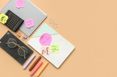 Planları, defterleri ve takvimi bej arka planda yapmak için yapışkan notlar. Yeni yıl hedefleri kavramı