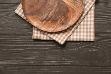 Tabak ayarı ve kahverengi ahşap arka planda kareli peçeteler