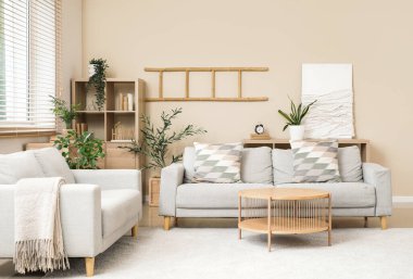 Gri koltukları ve kahve masası olan şık bir oturma odası.