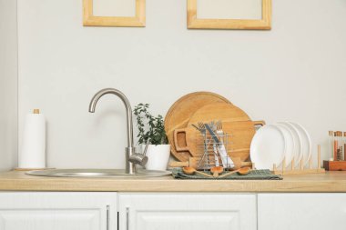 Mutfaktaki lavabonun yanında temiz tabaklar var.