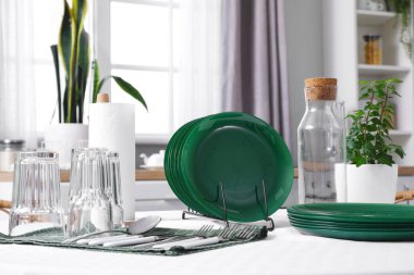 Mutfaktaki yemek masasında temiz tabaklar ve bardaklar.