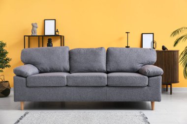 Turuncu duvarın yanındaki rahat kanepe şık bir oturma odasında.