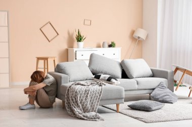 Evdeki deprem sırasında koltuğun yanında oturan kadın.