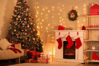 Şömineli şık bir oda, Noel ağacı, raf ünitesi ve hediye kutuları.