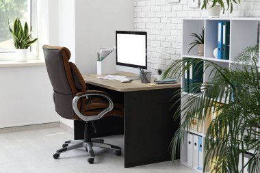 Çalışma yeri, koltuk, modern bilgisayar ve raf ünitesi olan ofis içi