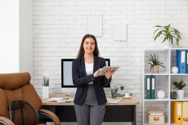İş yerinin yakınındaki iş yerinde tablet kullanan kadın ofis çalışanı