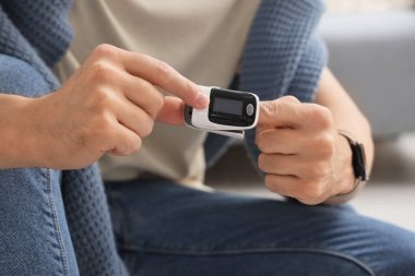 Nabız oksimetresi olan genç adam, yakın plan.