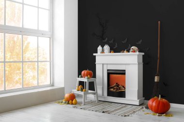 Cadılar Bayramı için şömine ve balkabaklarıyla dekore edilmiş oturma odasının içi.  