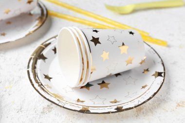 Grunge arka planında fincanları olan tek kullanımlık kağıt tabak, yakın plan