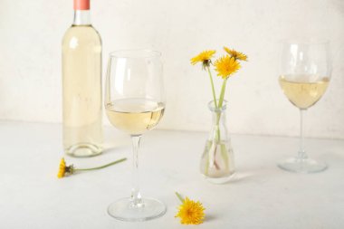 Beyaz masada bir şişe karahindiba şarabı.